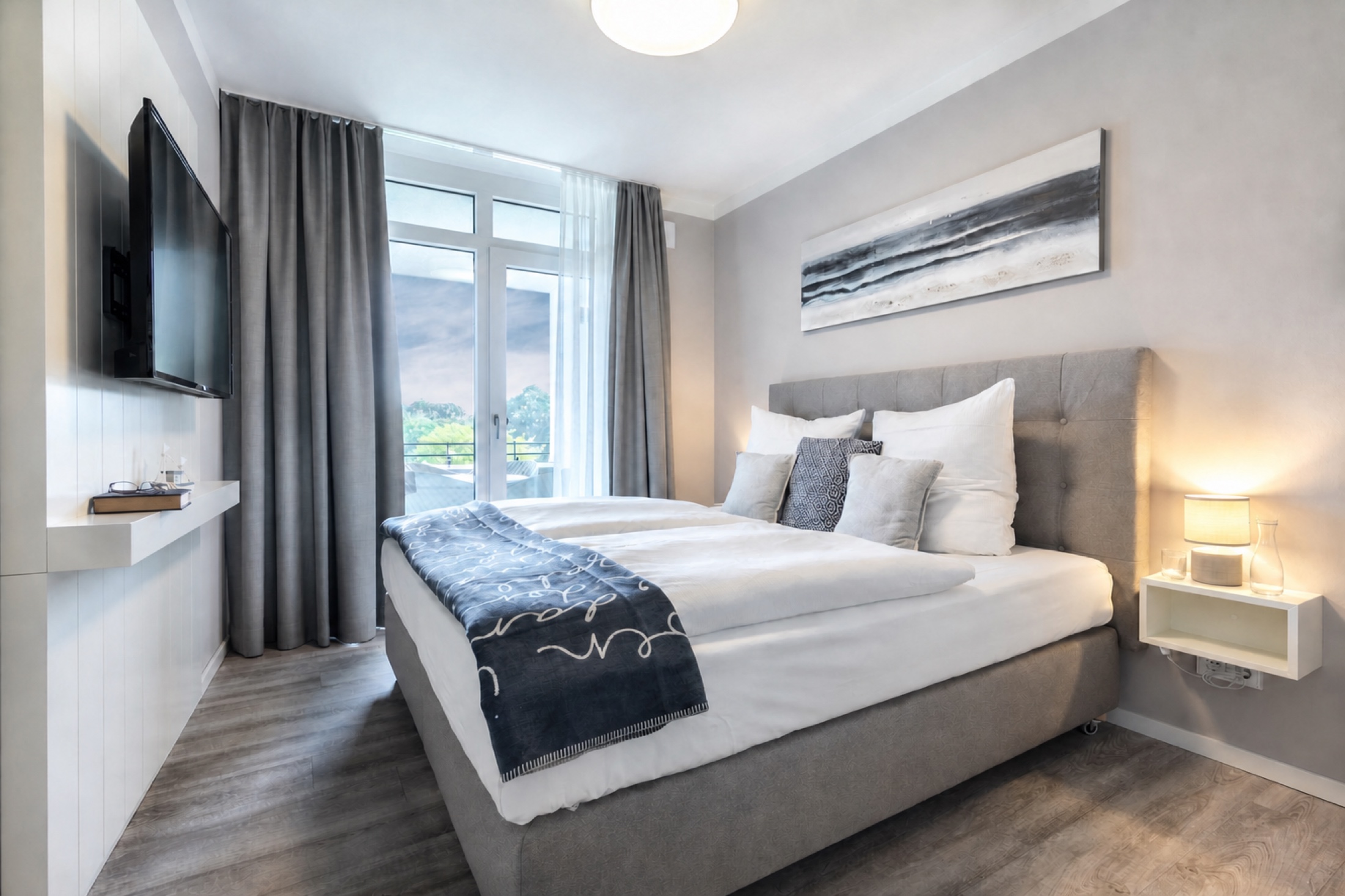 Schlafzimmer des TraveNest mit Buch, Lesebrille und Wasserkaraffe